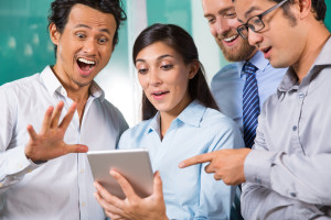 Shocked young business people using tablet. Amazed business team reading fresh news. Business concept